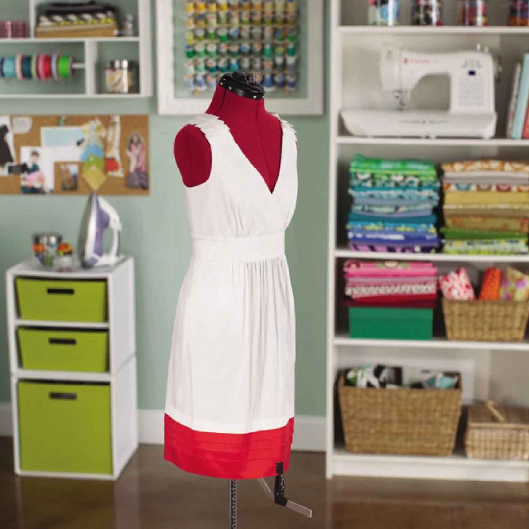 White dress fitted on the red SINGER 150 adjustable dress form in a sewing room